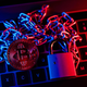 A chain and a padlock sitting on top of a keyboard awash in blue and red light. A gold bitcoin sits on top of the chain.